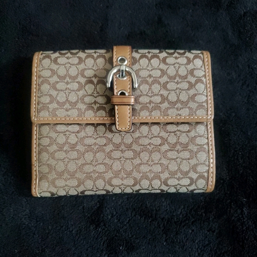 Coach signature canvas wallet with leather trim and a buckle closure